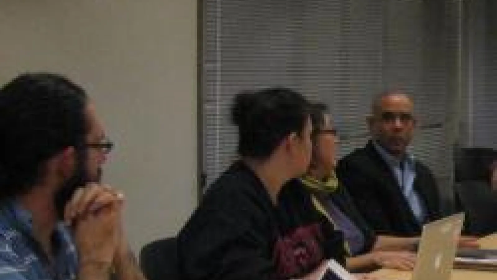 faculty and graduate students sit around the discussion table