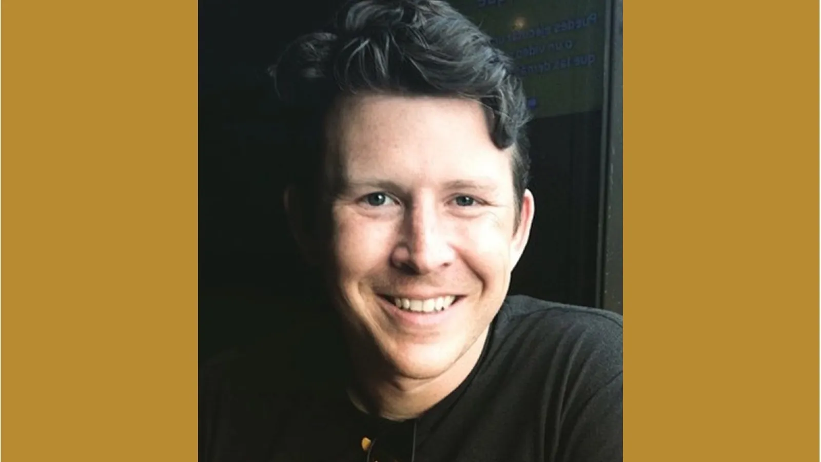 photo of Nick Kawa with darker colored hair and sunglasses hooked onto a dark shirt