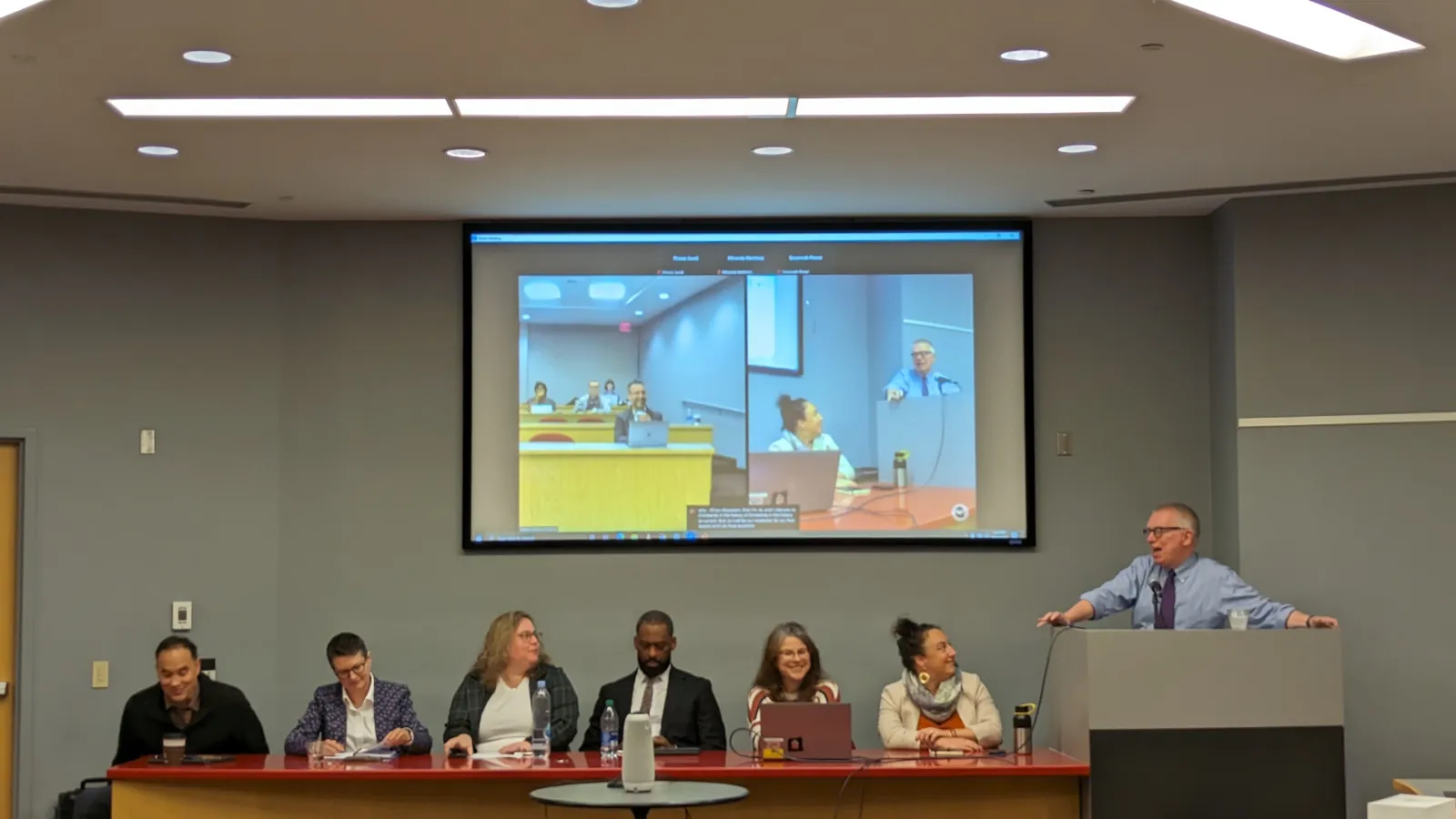 David leading a discussion panel of six participants