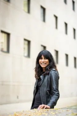 Sam with black jacket in front of white building
