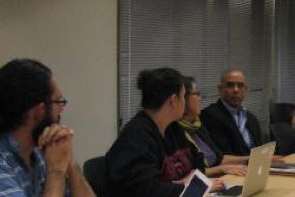 faculty and graduate students sit around the discussion table