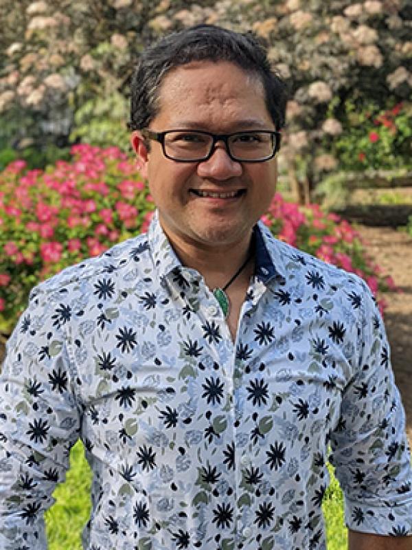 Mark Anthony with black glasses and a floral-leaf print