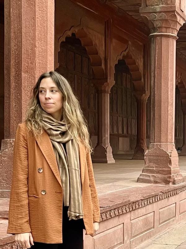 Kate Kaura in front of a red sandstone building in India 