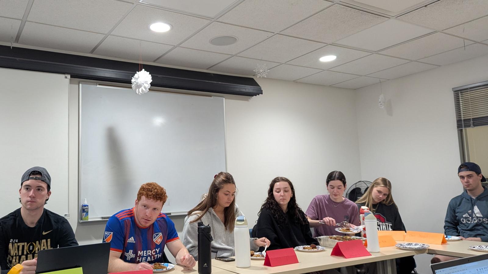 Students listening to Chef Avishar, while others are sampling the food he brought